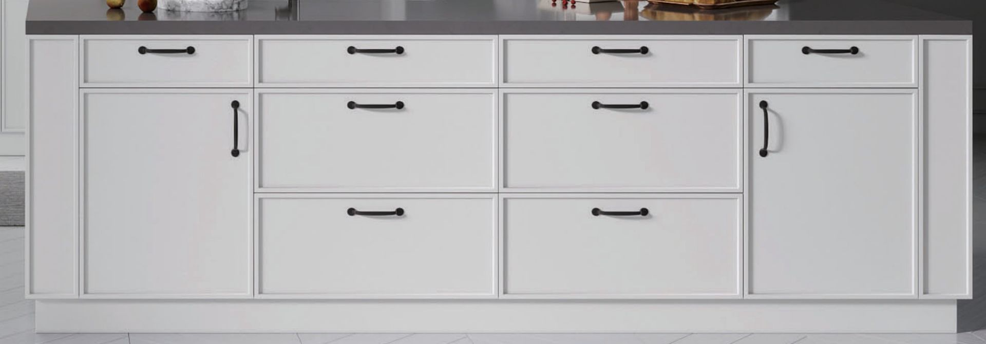 Close-up of white shaker drawer fronts with matte black pull handles